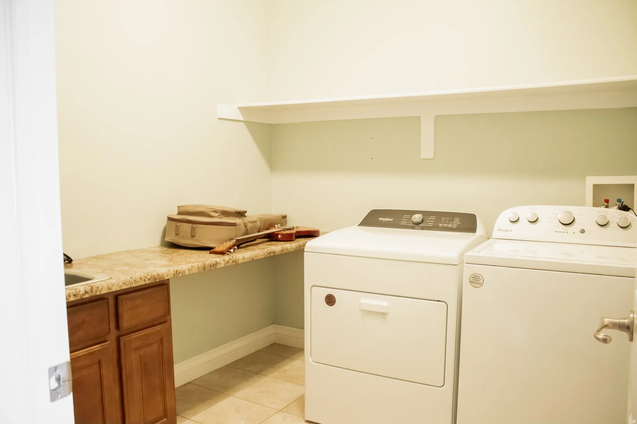 Laundry area with separate washer and dryer and light tile patterned flooring
