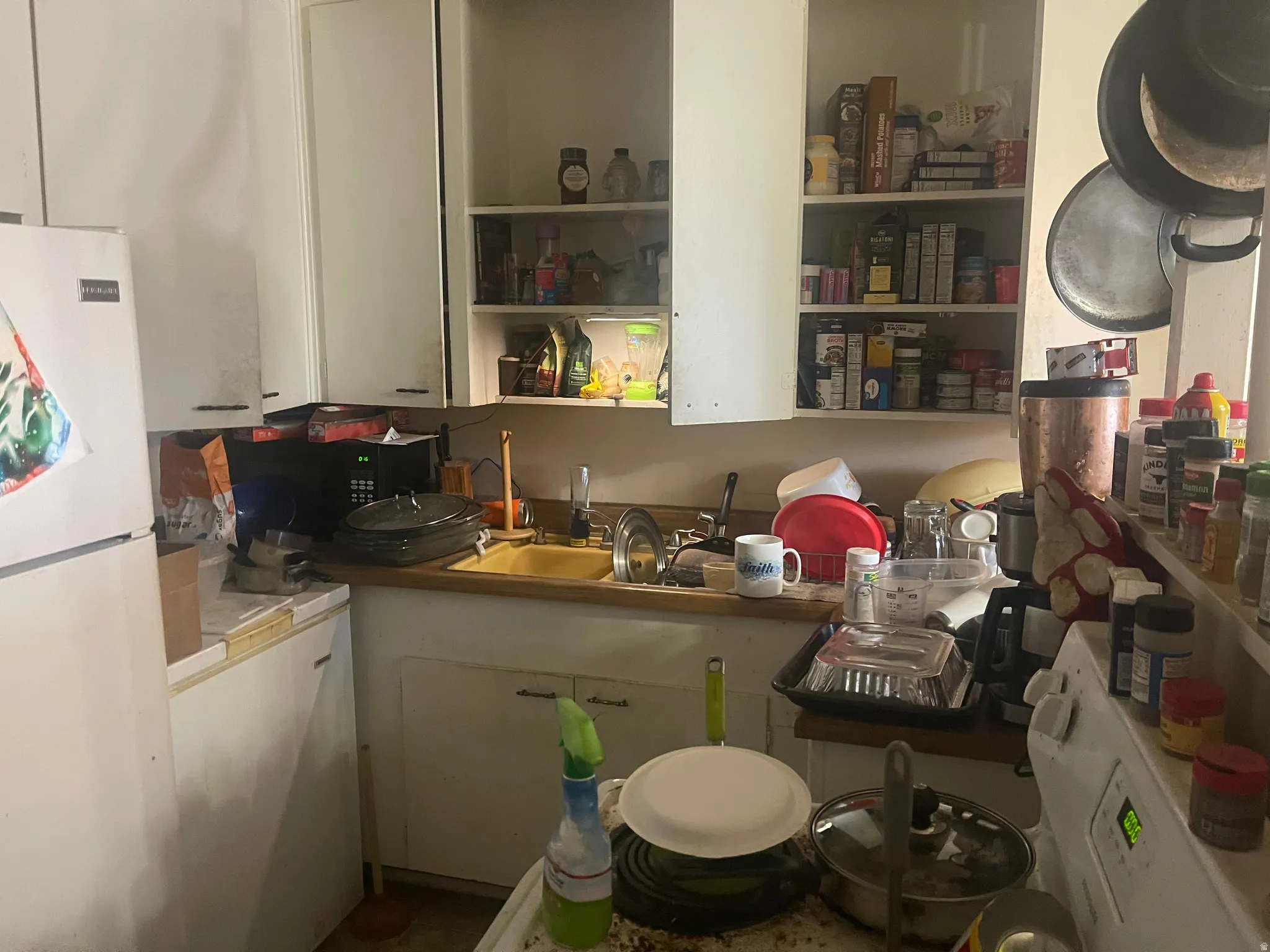 Kitchen with freestanding refrigerator and white cabinetry