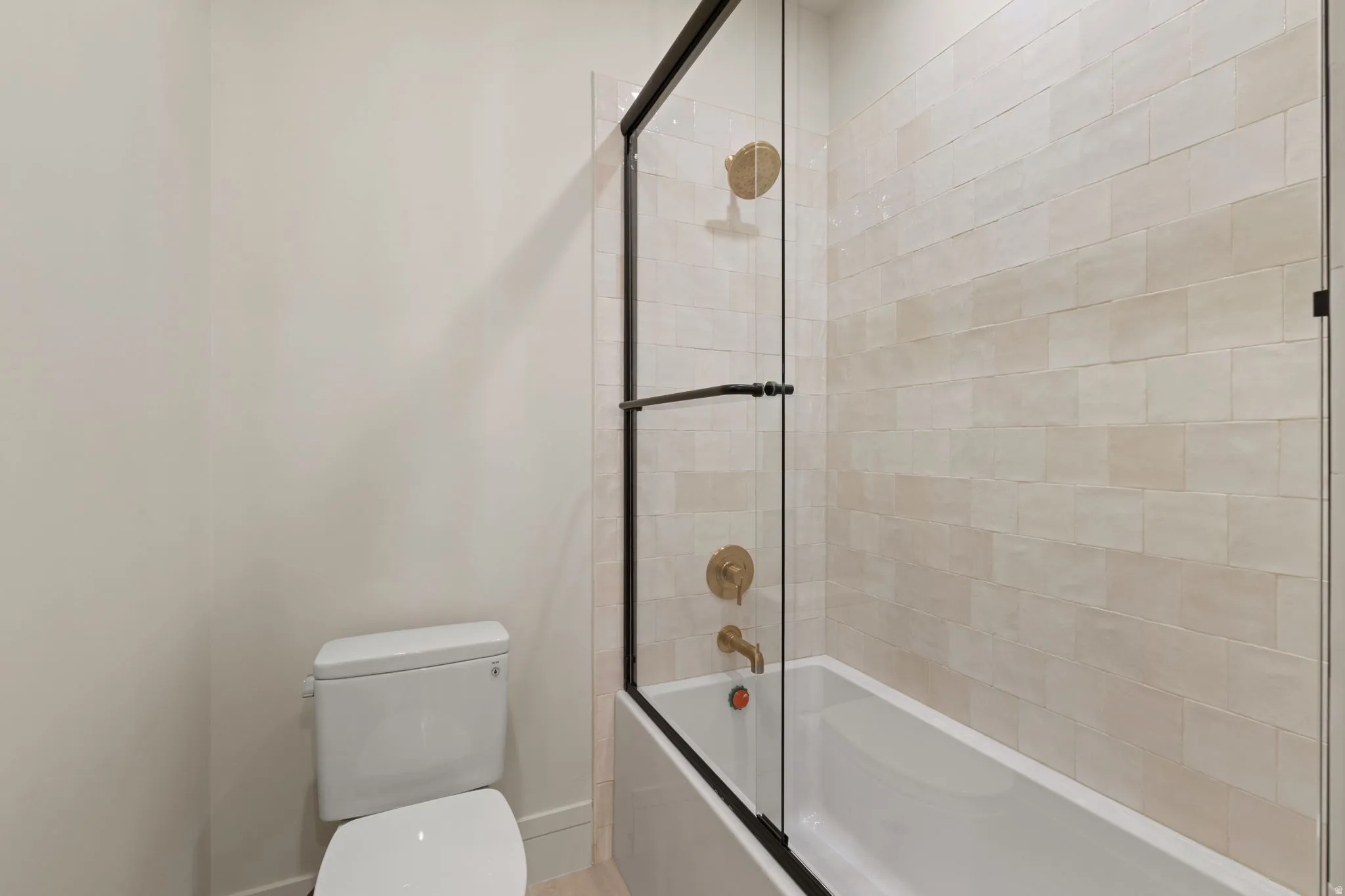 Bathroom with enclosed tub / shower combo and toilet