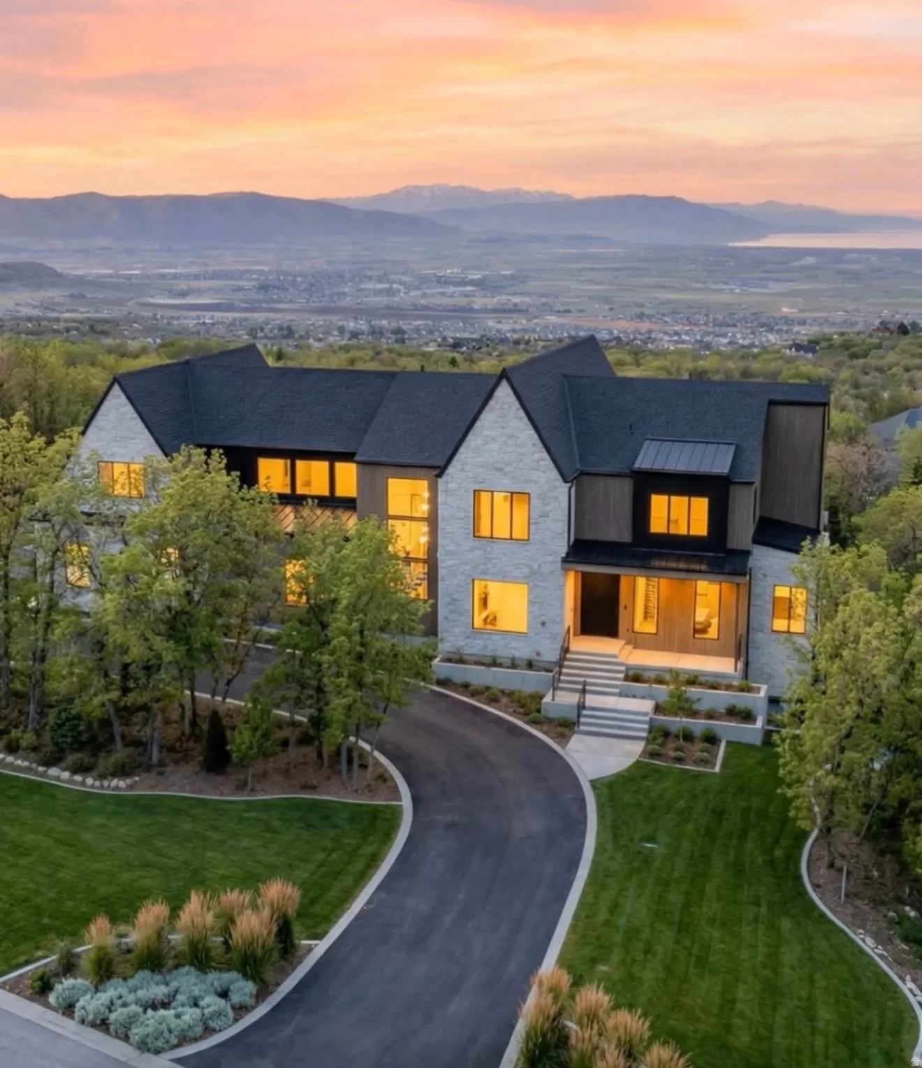 Contemporary home with stone siding, a front lawn, a mountain view, and a standing seam roof