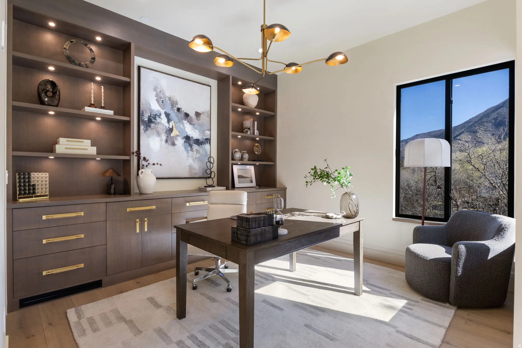 Office area with built in features, a chandelier, and light wood-style floors