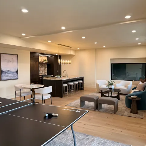 Recreation room with light wood-style flooring and recessed lighting