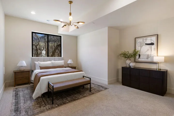 Bedroom featuring carpet and hanging lights