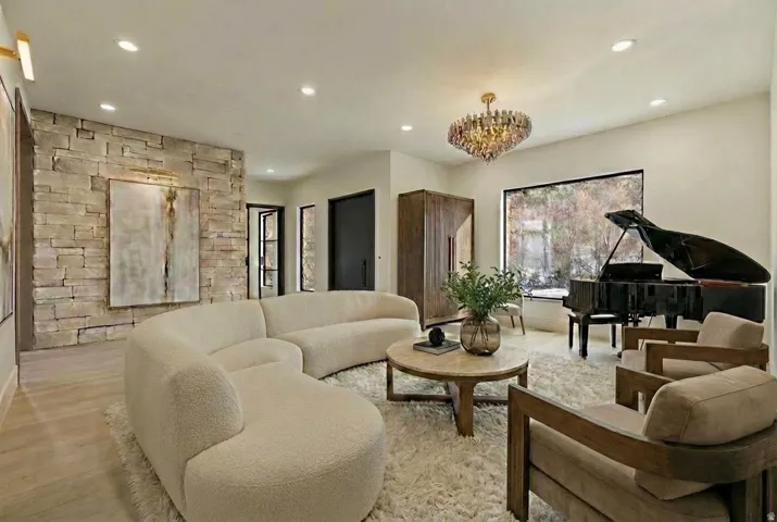 Living area featuring light wood finished floors and a chandelier