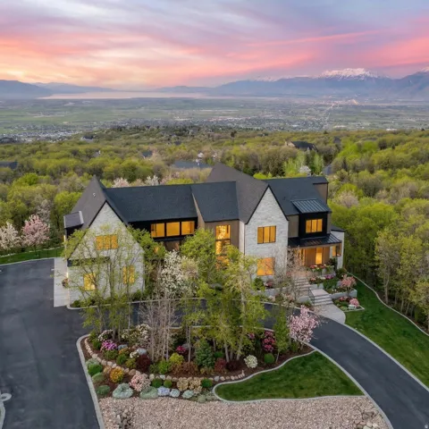 View of front of home with stone siding, a standing seam roof, a mountain view, and a balcony