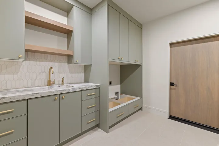 Laundry room featuring cabinet space, light tile patterned floors, and electric dryer hookup