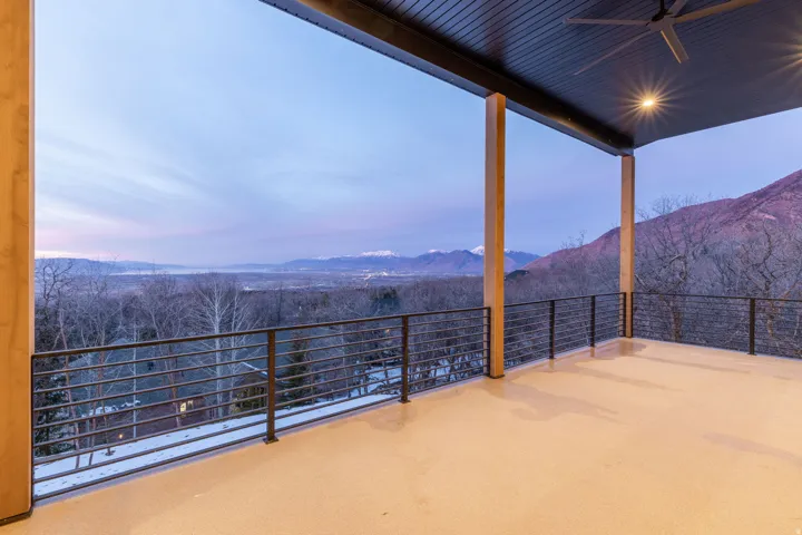 Patio terrace at dusk featuring a patio area, a ceiling fan, and a mountain view