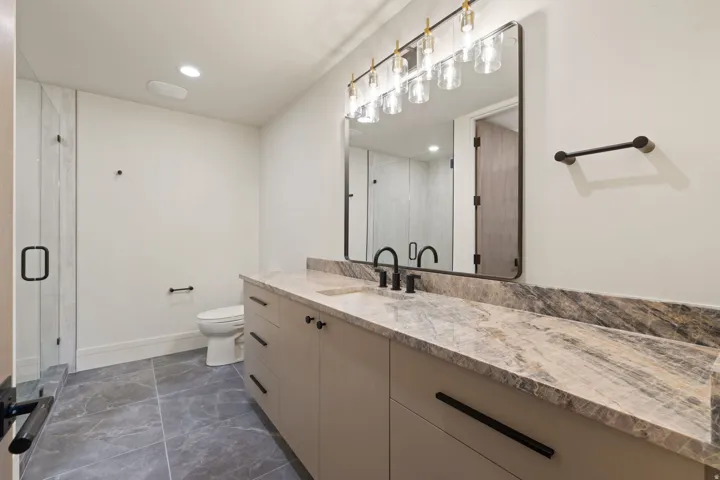 Full bathroom with vanity, a stall shower, dark marble finish flooring, and recessed lighting