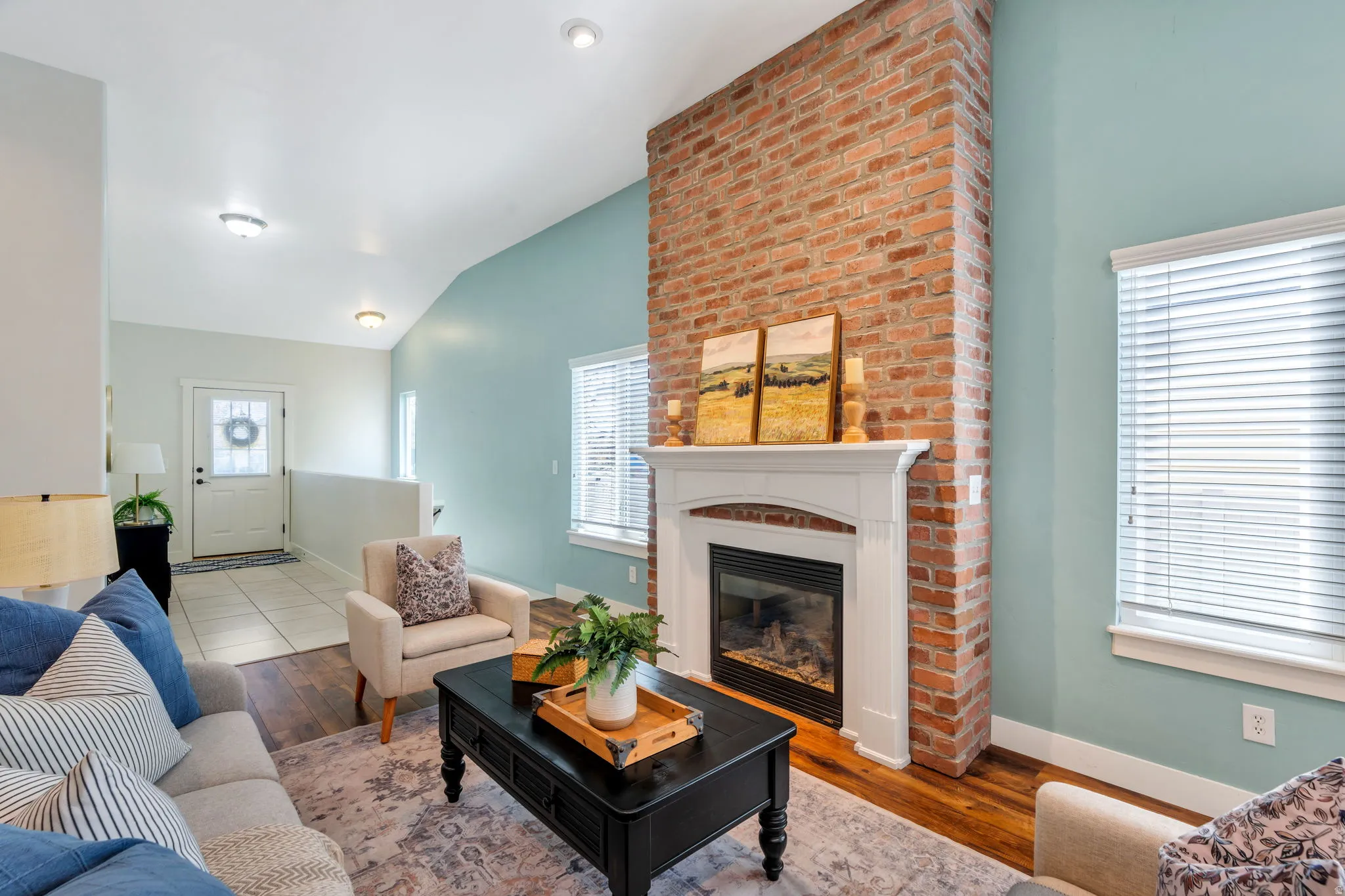 Warm and inviting gas fireplace with floor-to-ceiling brick front is the centerpiece of the great room.