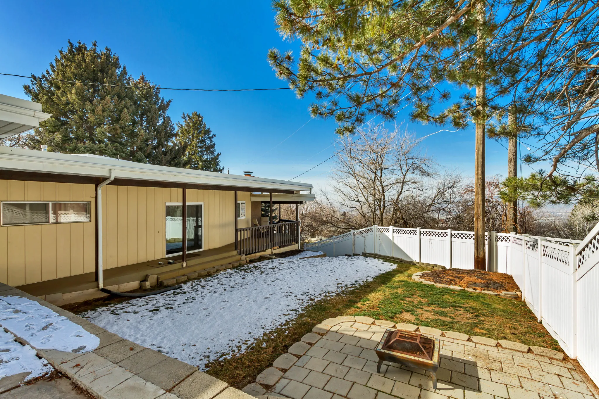 Fenced backyard featuring an outdoor fire pit and a patio area