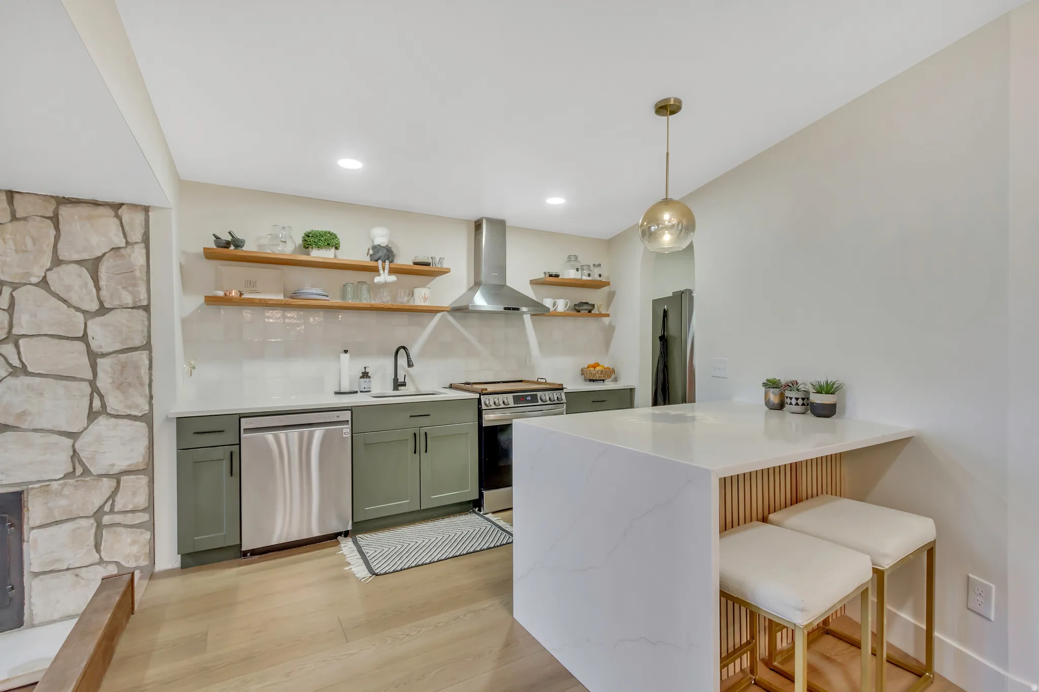 Kitchen with a kitchen breakfast bar, open shelves, backsplash, light stone countertops, and light wood-type flooring