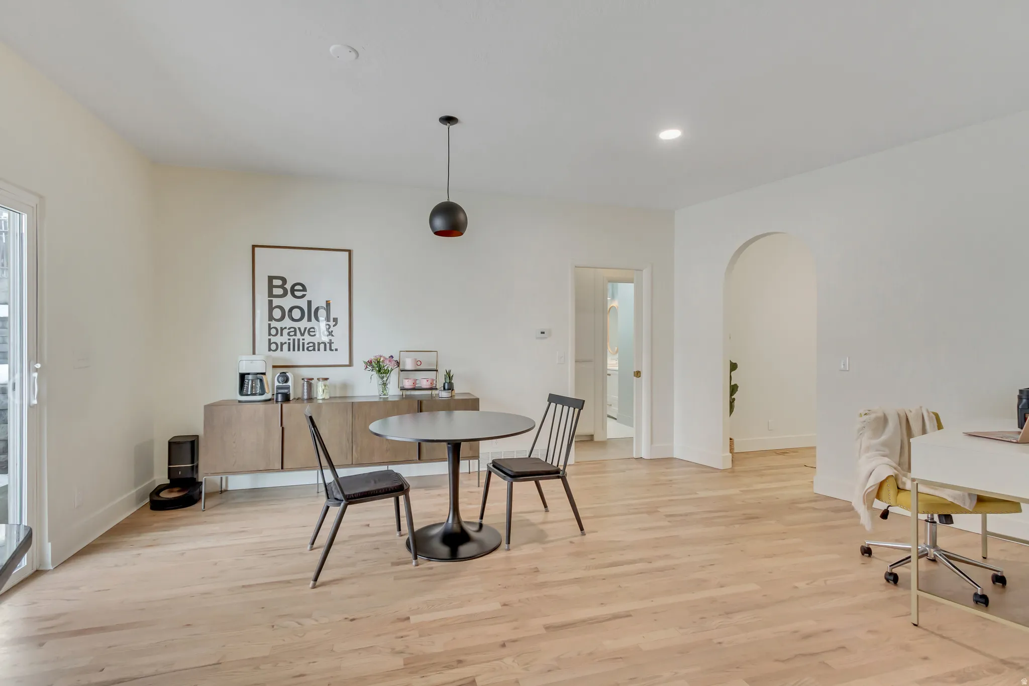Dining room featuring light wood-type flooring, arched walkways, and recessed lighting