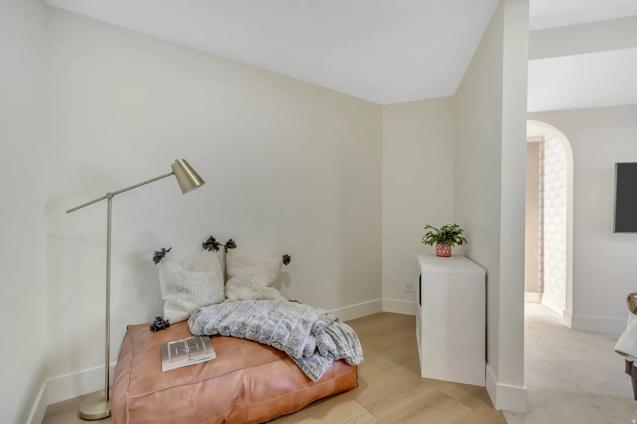 Bedroom with light wood-type flooring and arched walkways