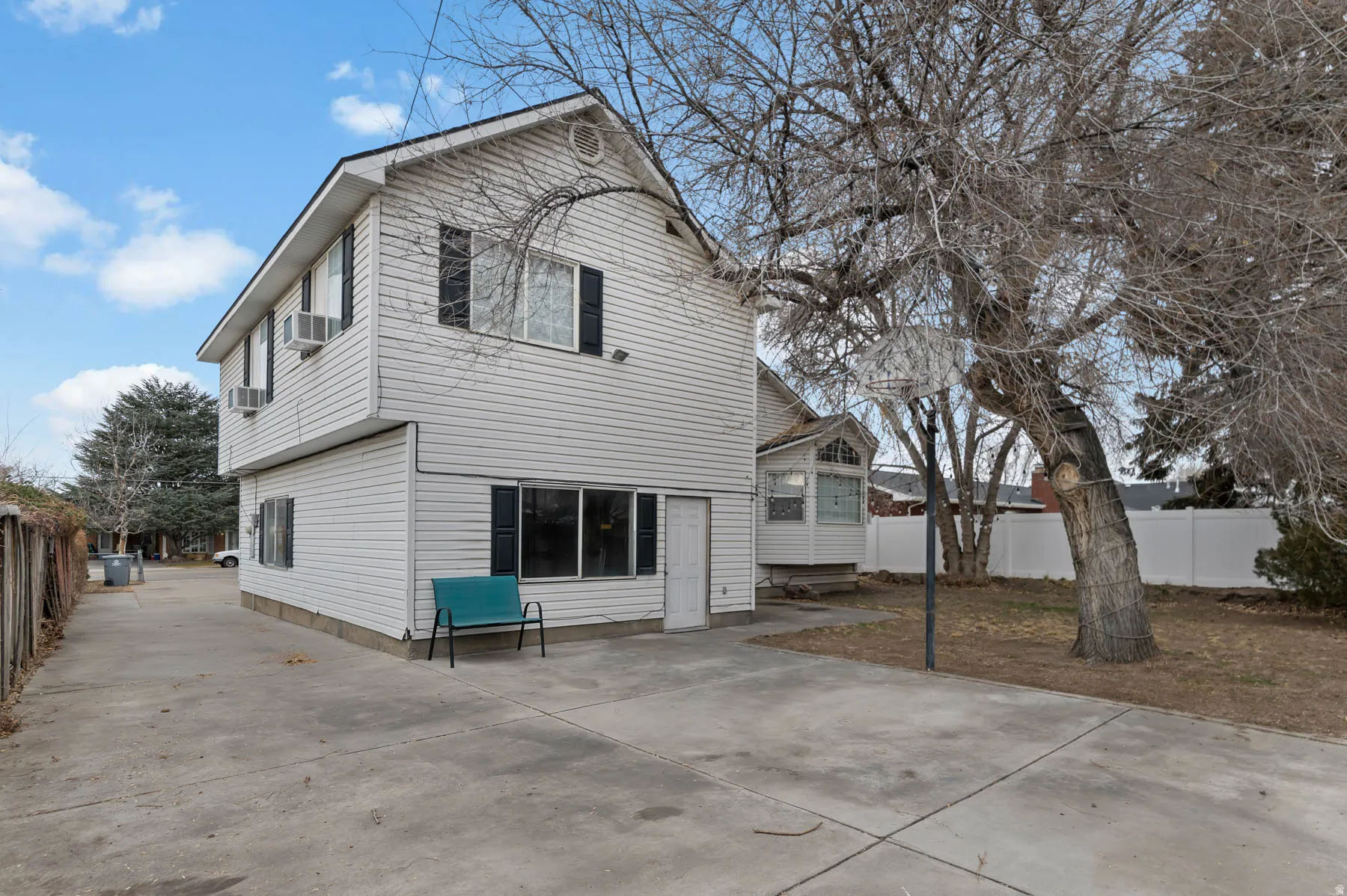 Rear view of house with a fenced backyard and a patio
