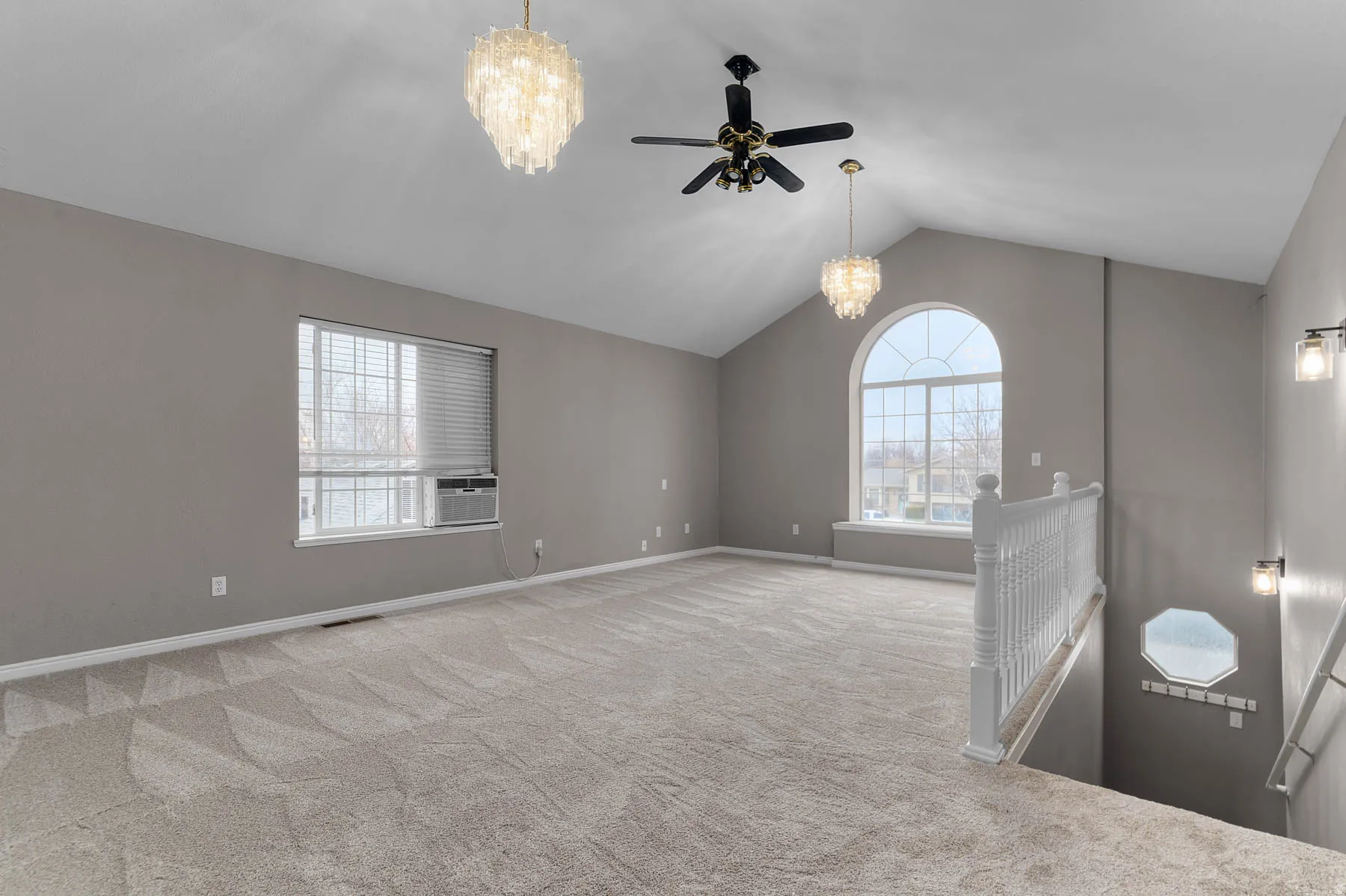 Spare room with suspended lighting, carpet floors, plenty of natural light, and a ceiling fan