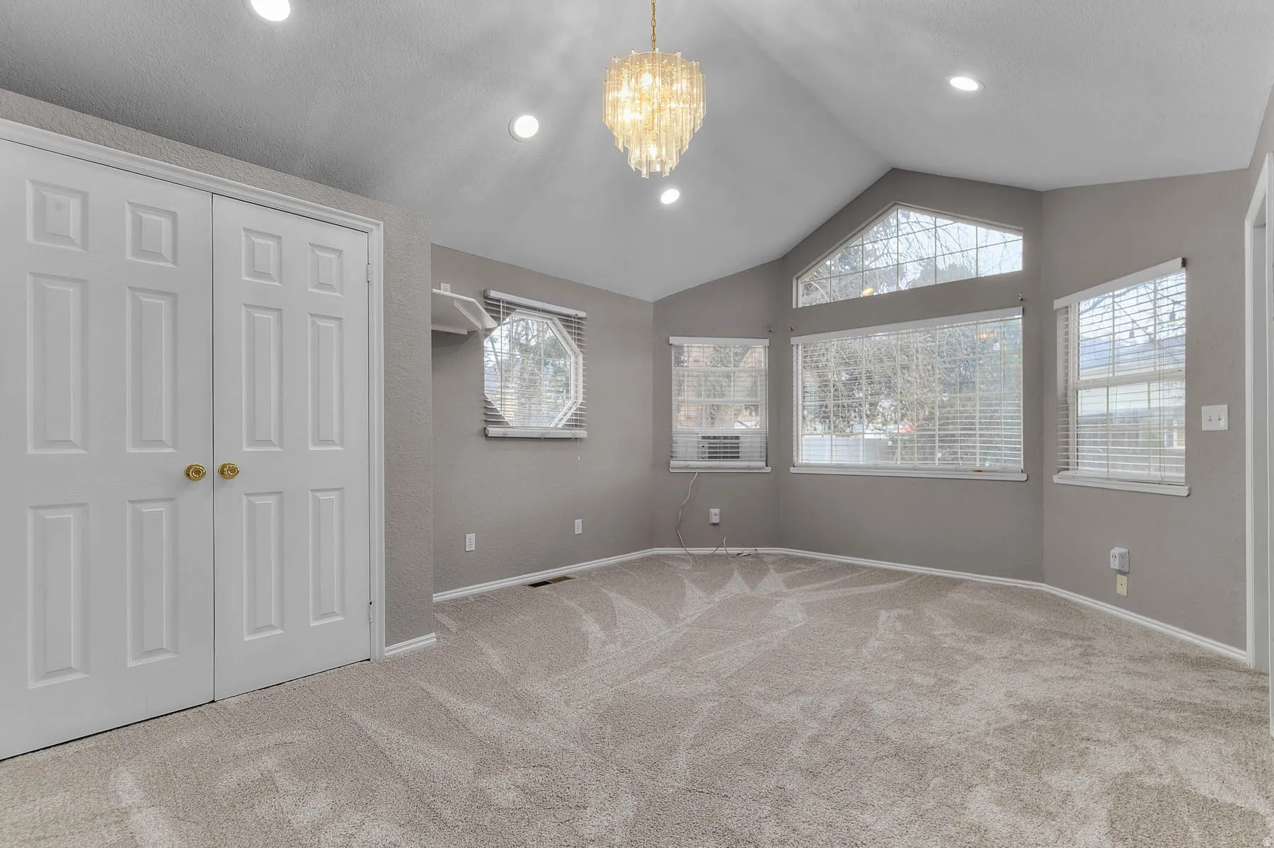 Unfurnished bedroom with suspended lighting, a closet, and light carpet