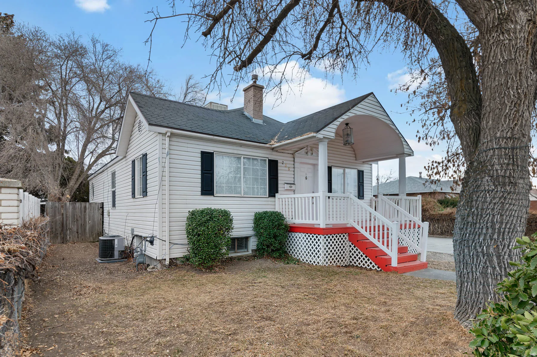 View of front facade with a chimney and a shingled roof