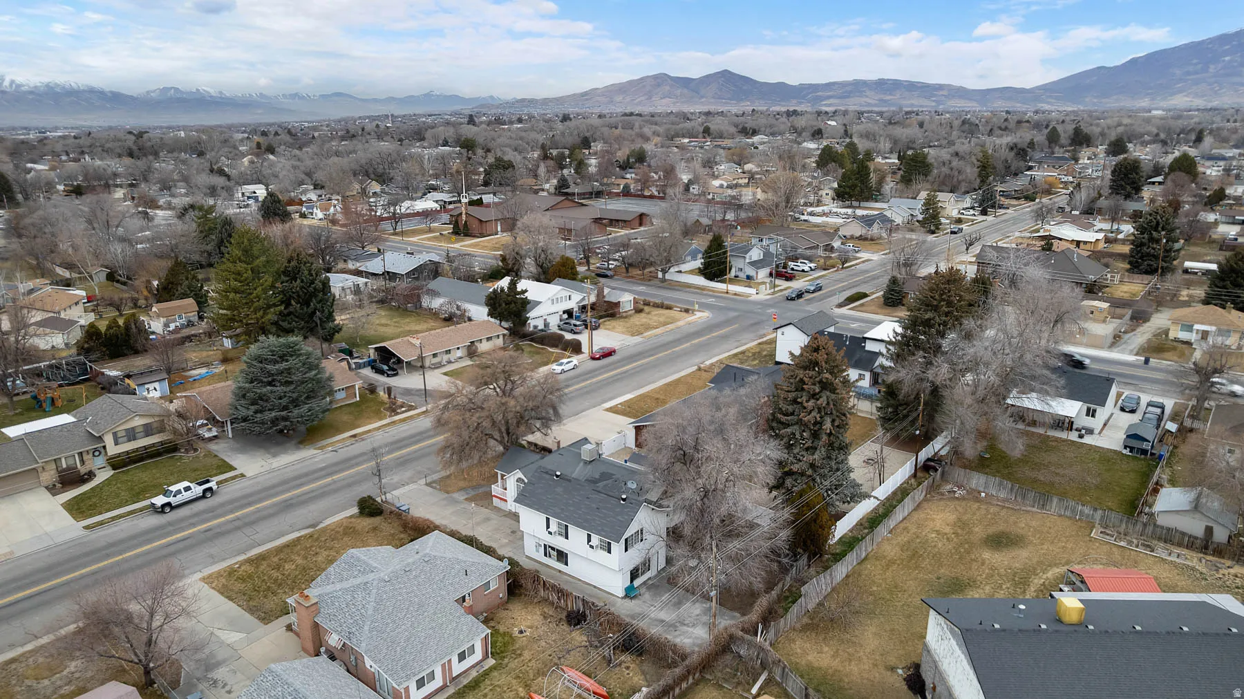 Aerial view of property's location with nearby suburban area and a mountainous background