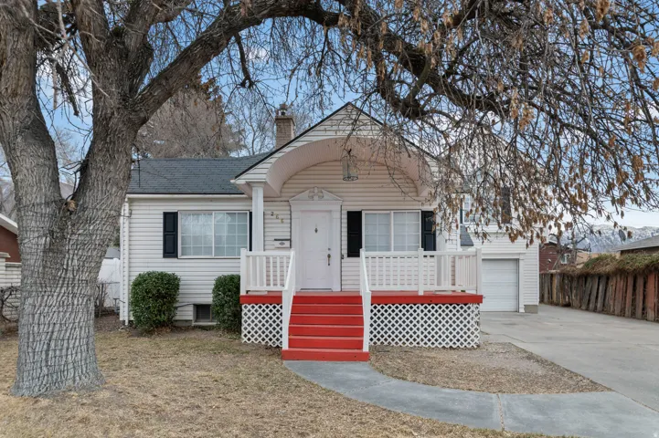 View of front of house featuring a chimney, concrete driveway, roof with shingles, and a garage