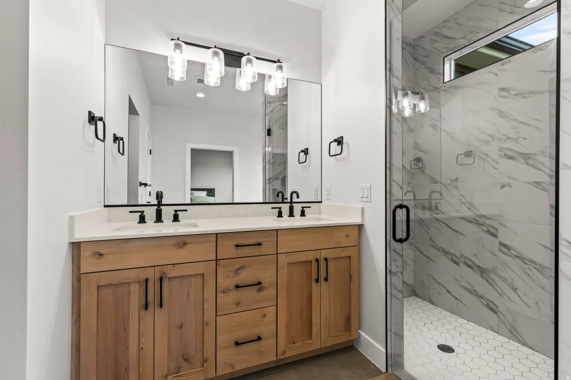 Bathroom featuring double vanity and a marble finish shower