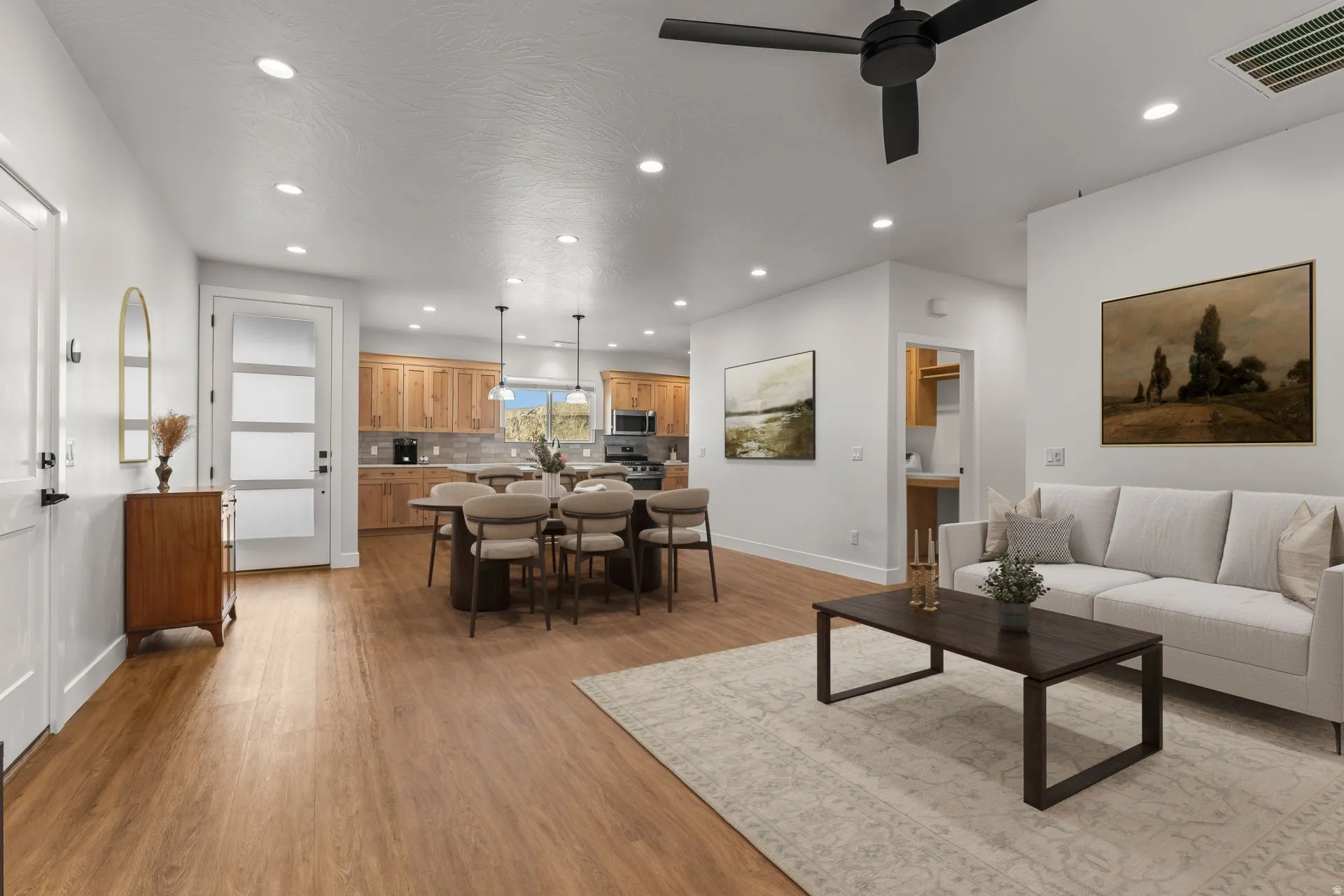 Living room featuring light wood-type flooring, recessed lighting, and a ceiling fan