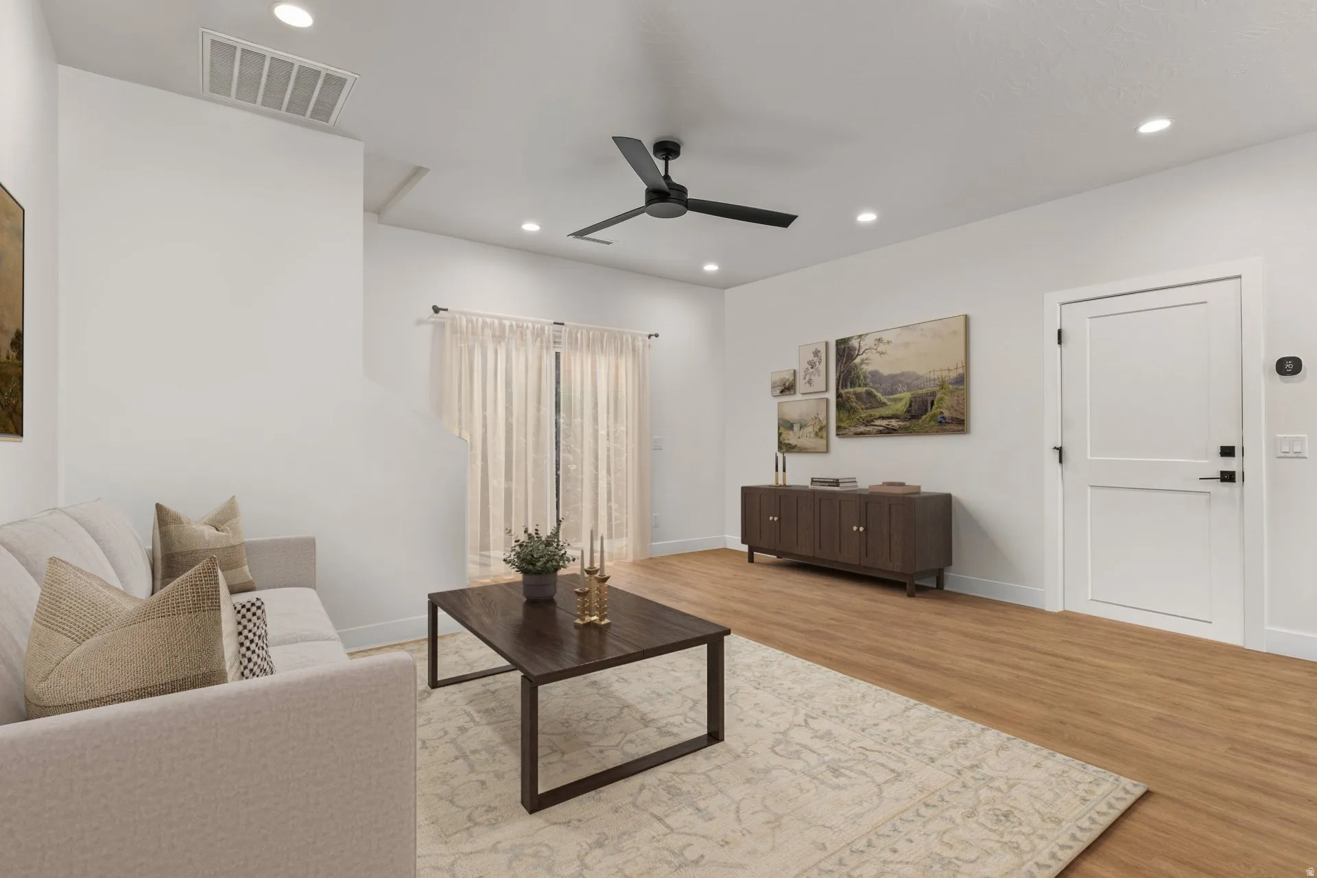 Living area featuring light wood-type flooring, ceiling fan, and recessed lighting