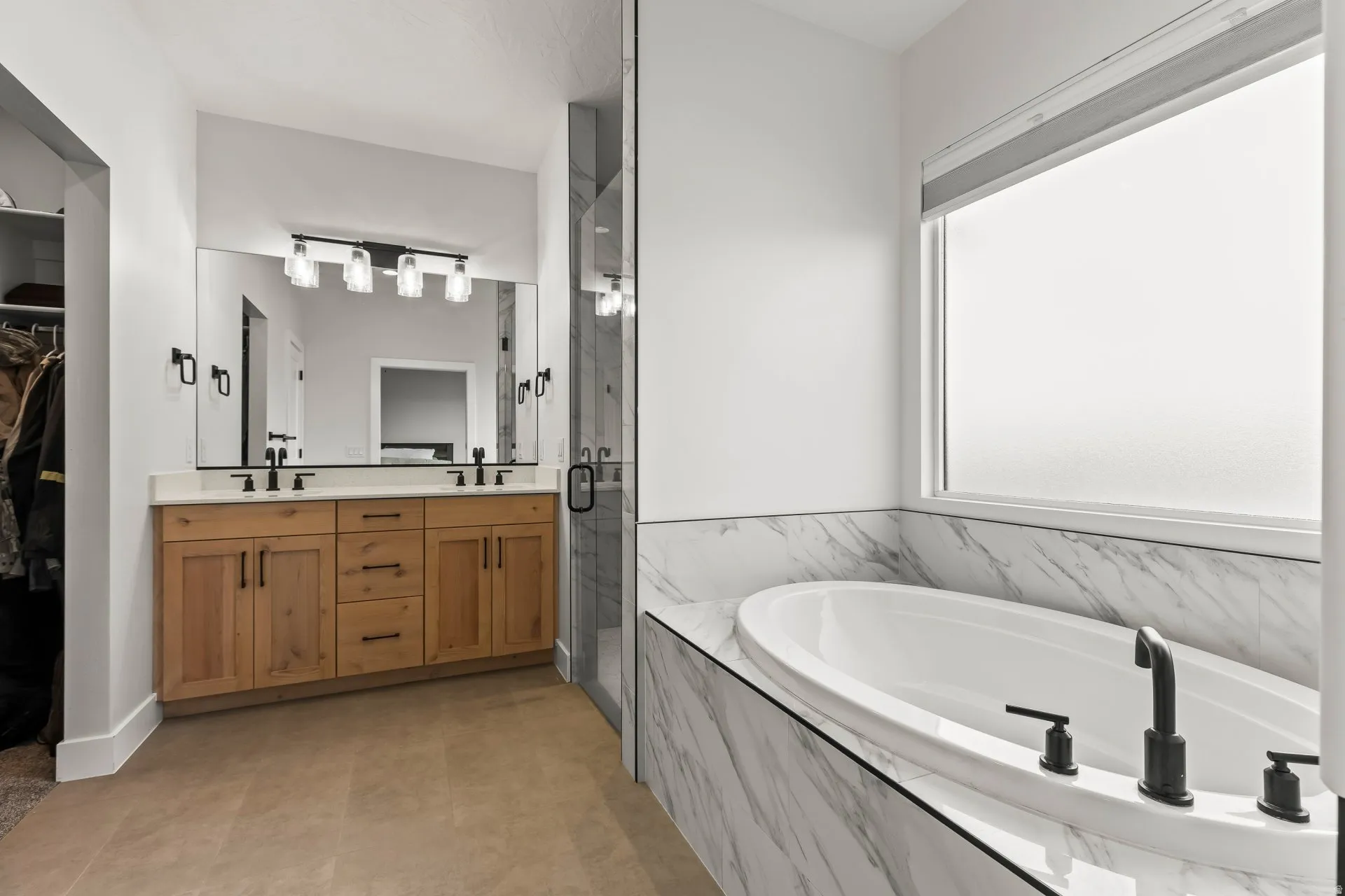 Bathroom featuring a marble finish shower, a bath, double vanity, and a walk in closet