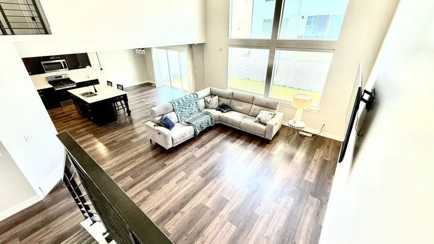 Expansive open-concept living space featuring high ceilings and wood-finish flooring