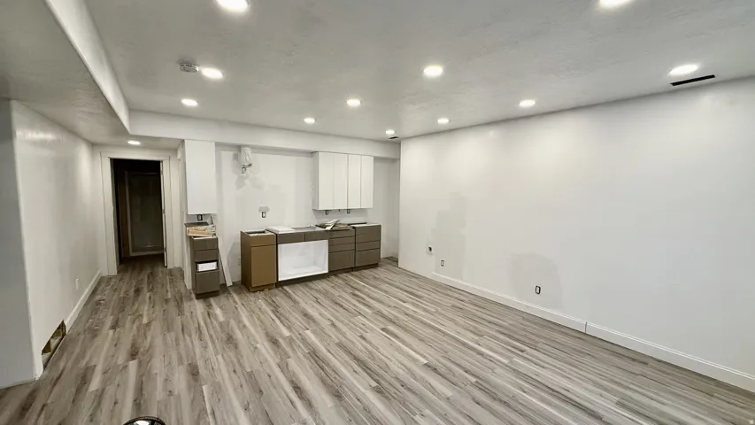 Open-concept room featuring wood-finish flooring, recessed lighting, and white walls