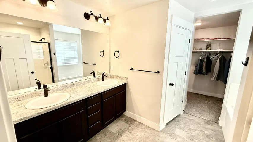 Spacious bathroom featuring a dual vanity with dark wood cabinetry and light-toned countertops