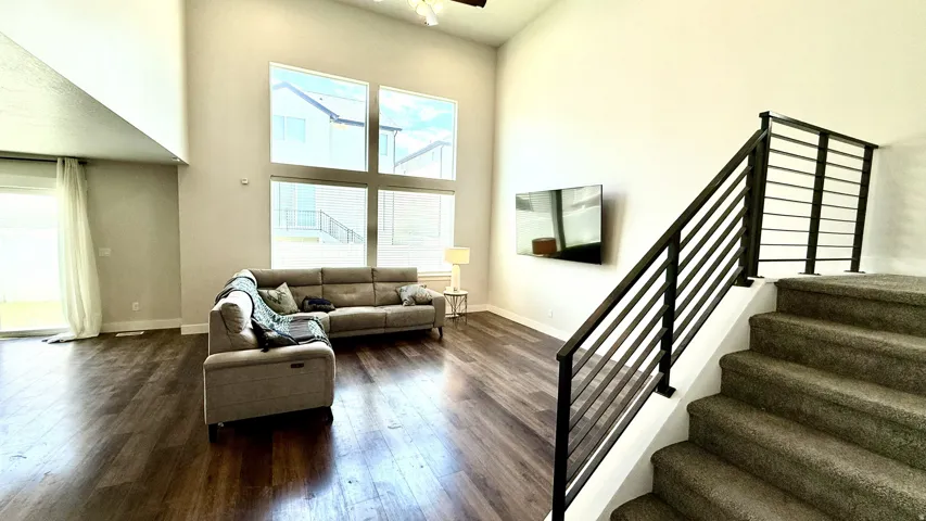 Open-concept living area with expansive wood-finish flooring, soaring ceilings, and large multi-pane windows