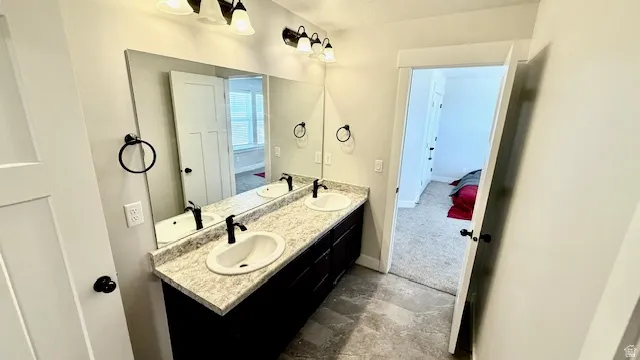 Dual vanity with integrated sinks, granite-look countertop, and dark cabinetry