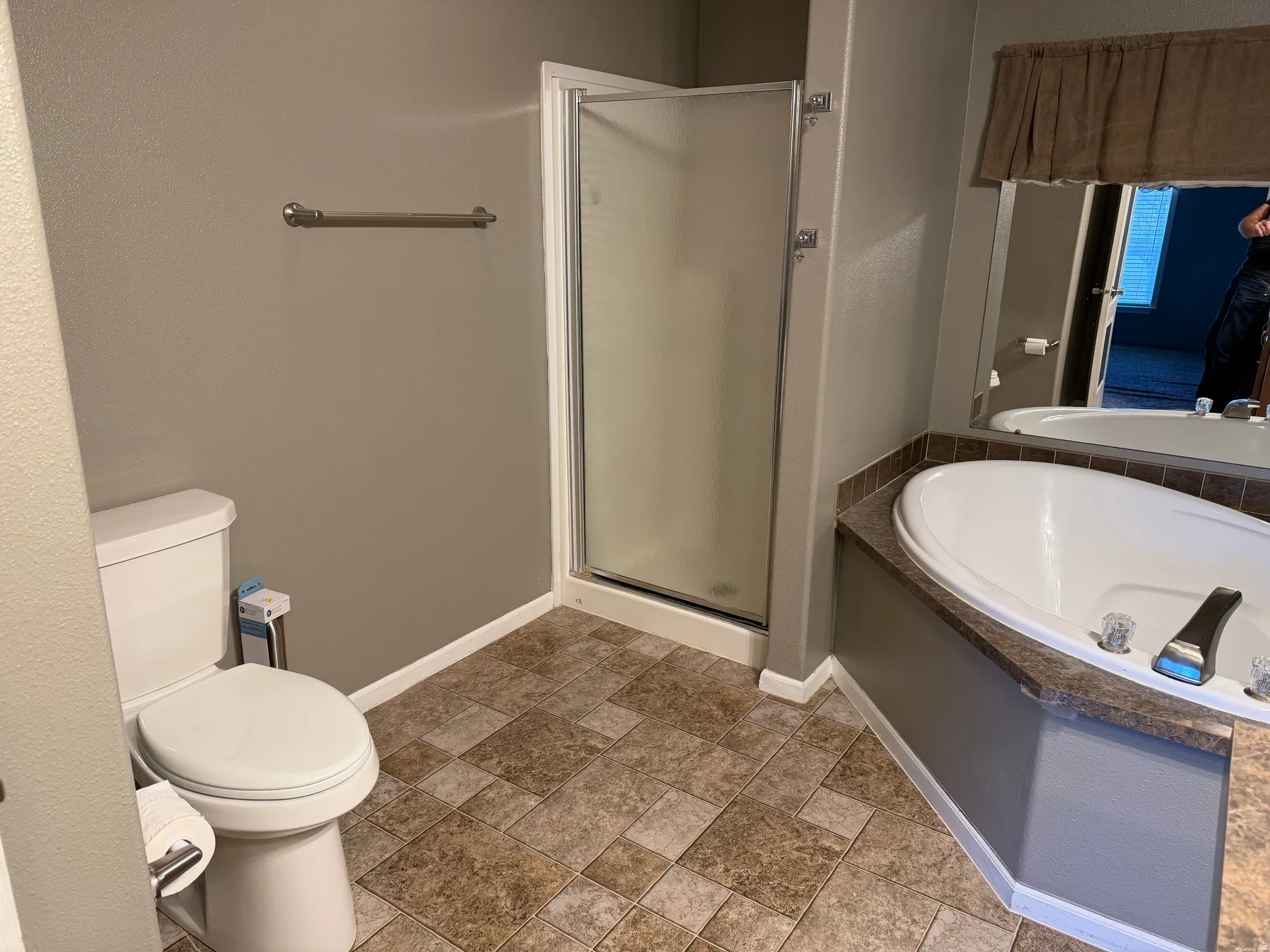 Bathroom with a shower stall, stone finish floors, and a garden tub