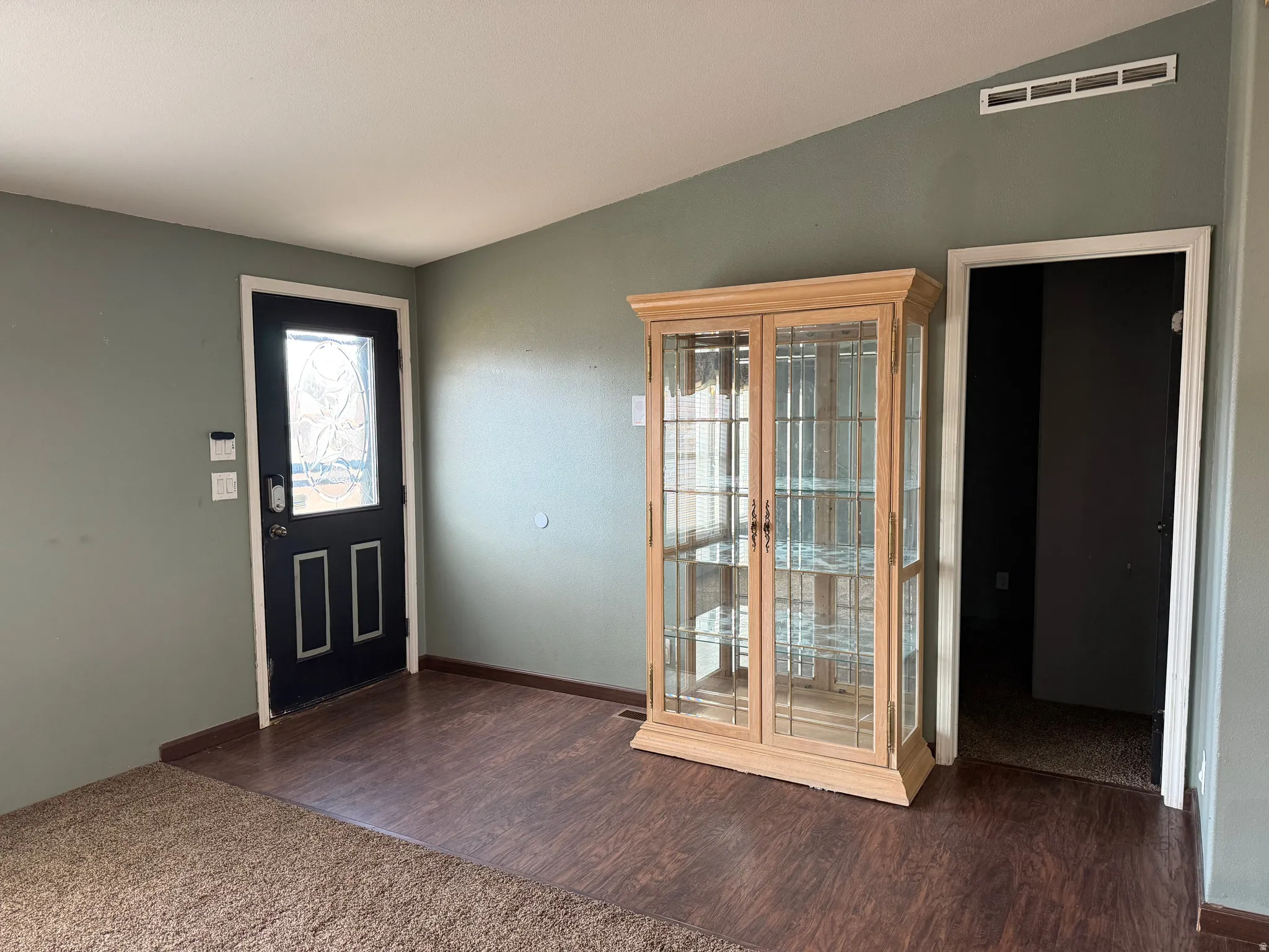 Entryway with lofted ceiling and dark wood-style flooring