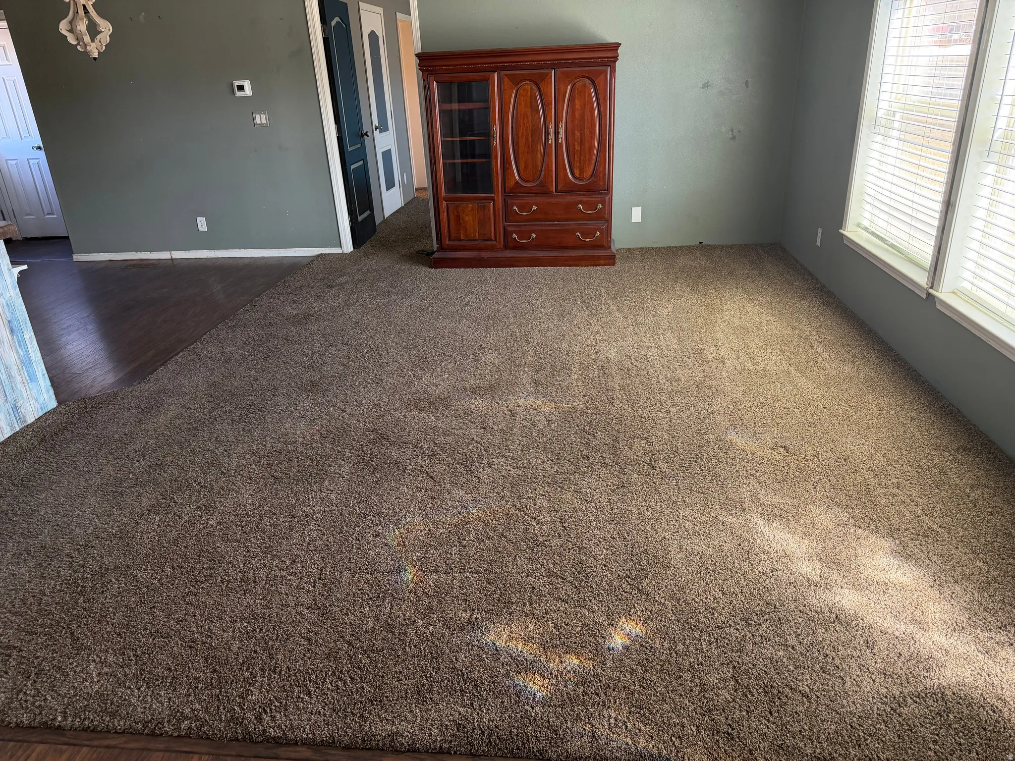 Unfurnished living room featuring dark colored carpet