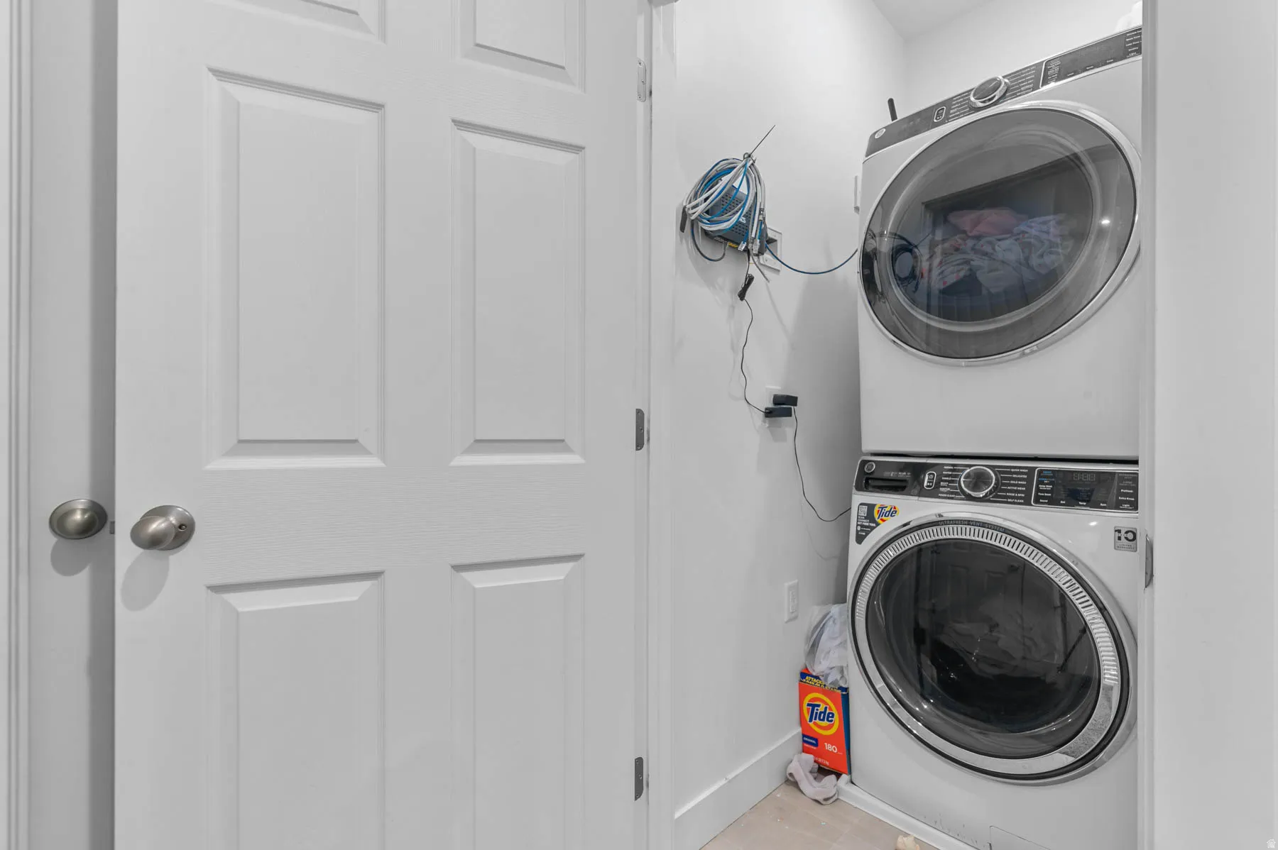Laundry room with stacked washer and clothes dryer included