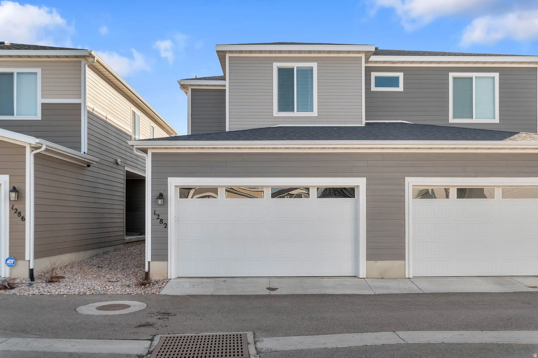 View of rear of house with roof with shingles and an attached garage