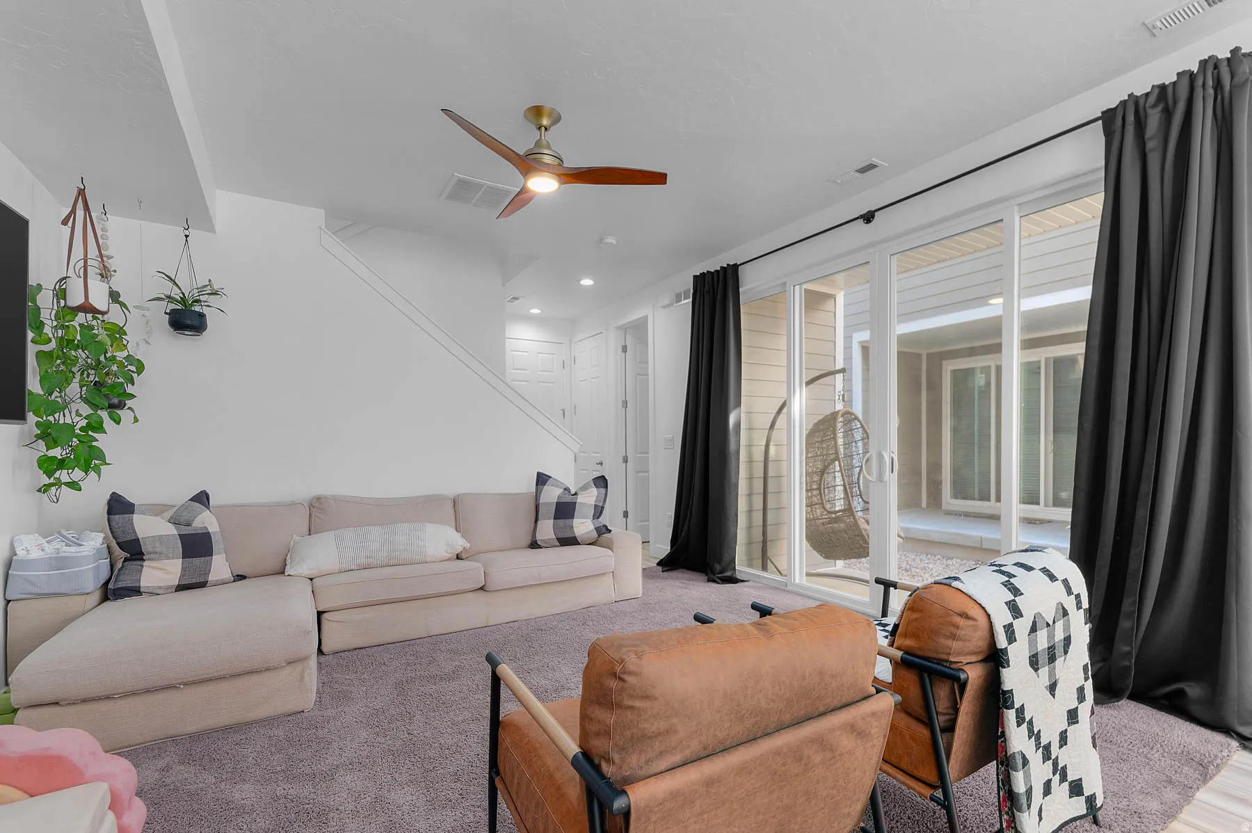 Carpeted living area with a ceiling fan and recessed lighting