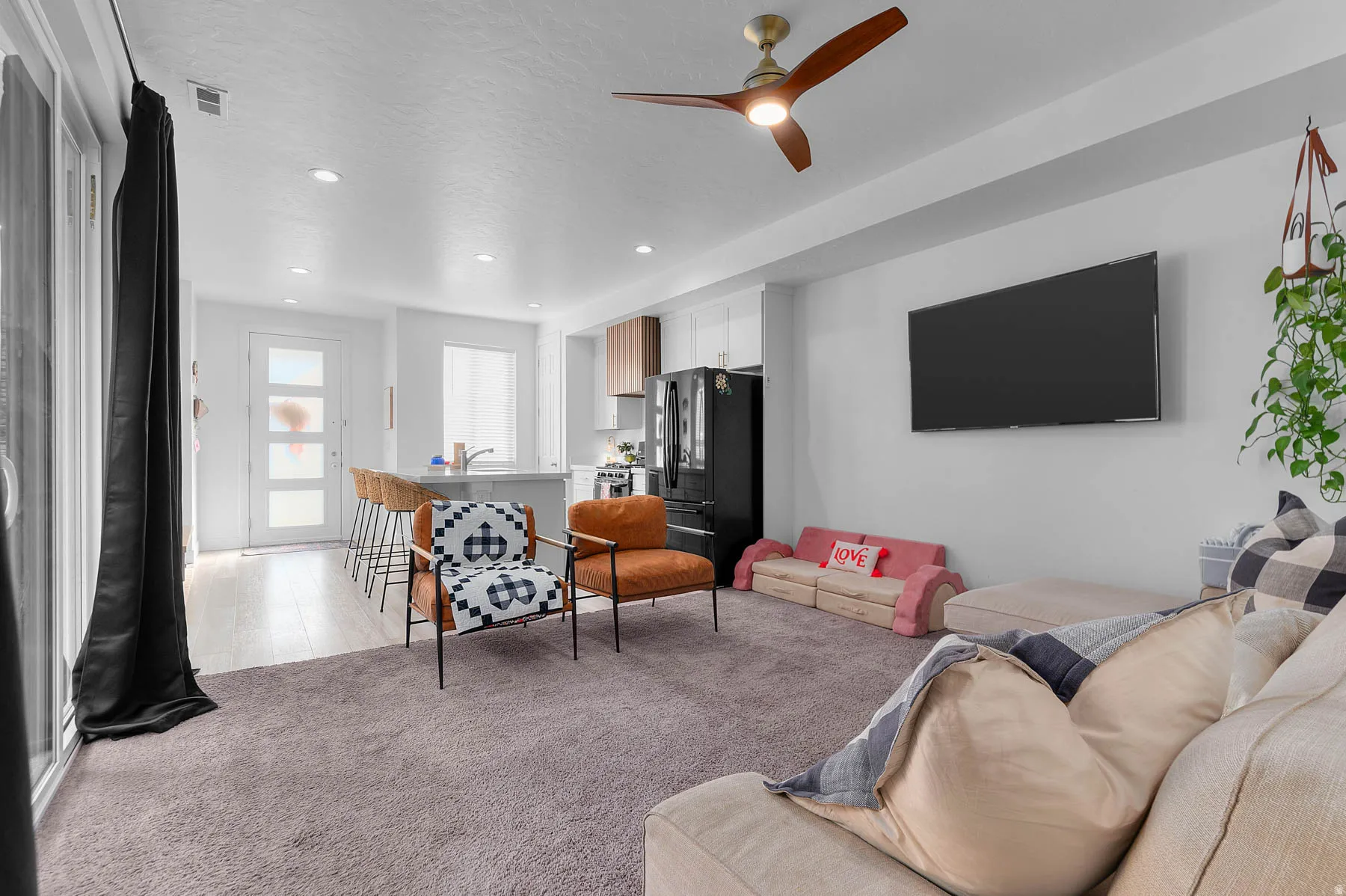 Living room featuring light colored carpet, ceiling fan, and recessed lighting