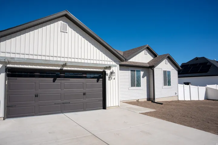 Modern farmhouse style home featuring roof with shingles, concrete driveway, and board and batten siding