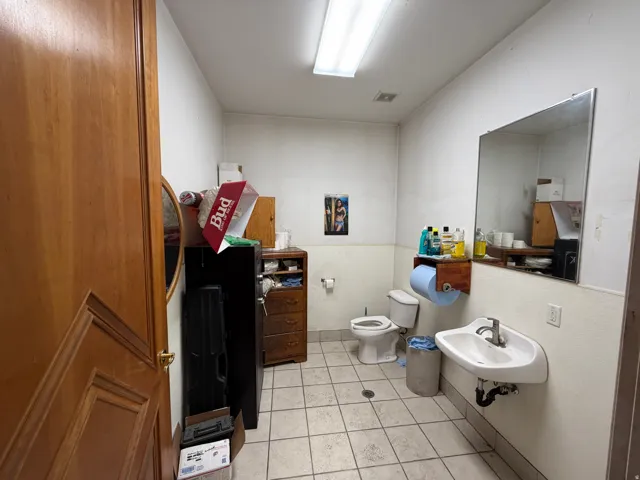 Half bath featuring toilet and light tile patterned floors