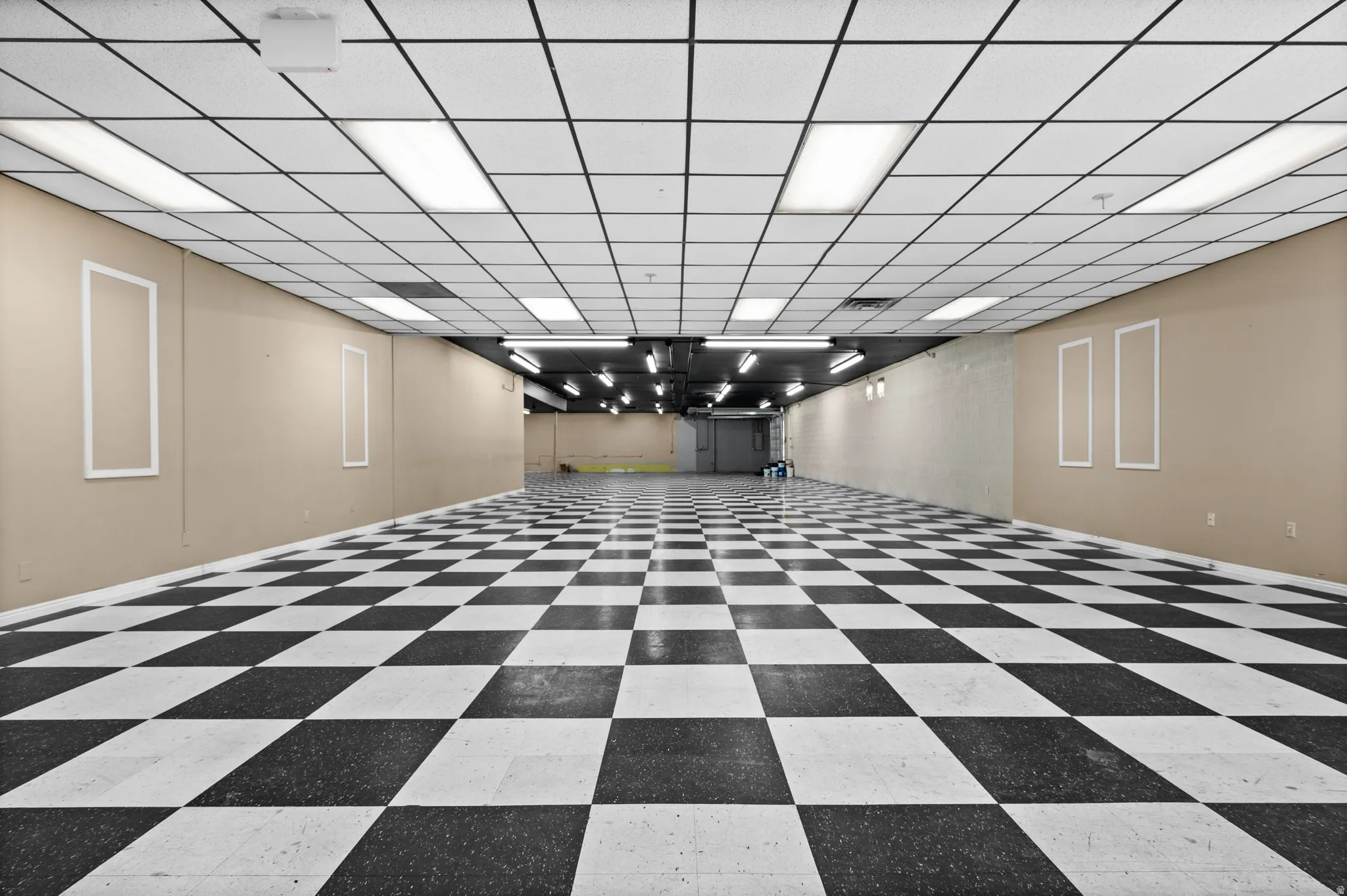 Basement with a paneled ceiling and baseboards