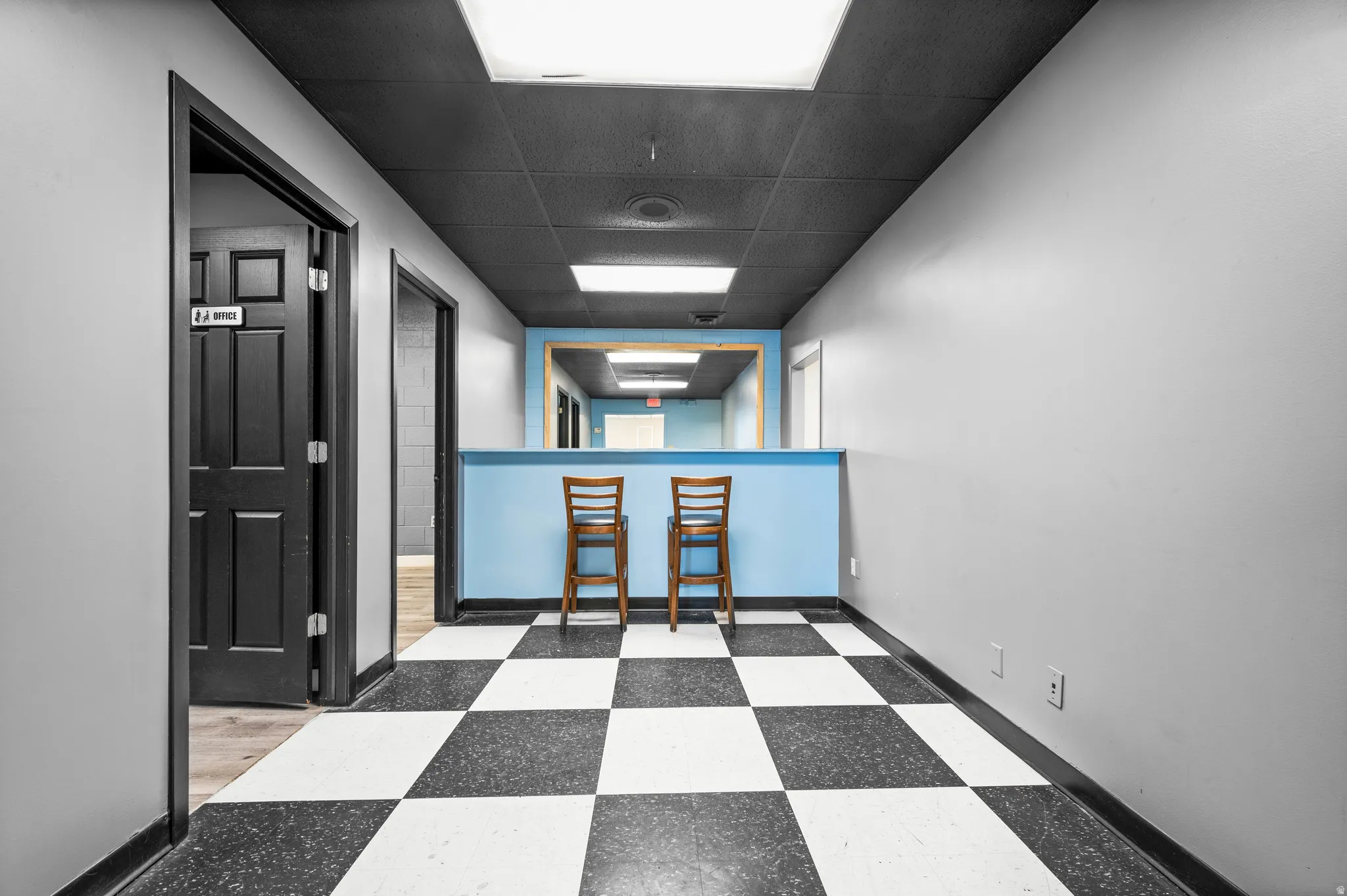 Empty room with a paneled ceiling and tile patterned floors