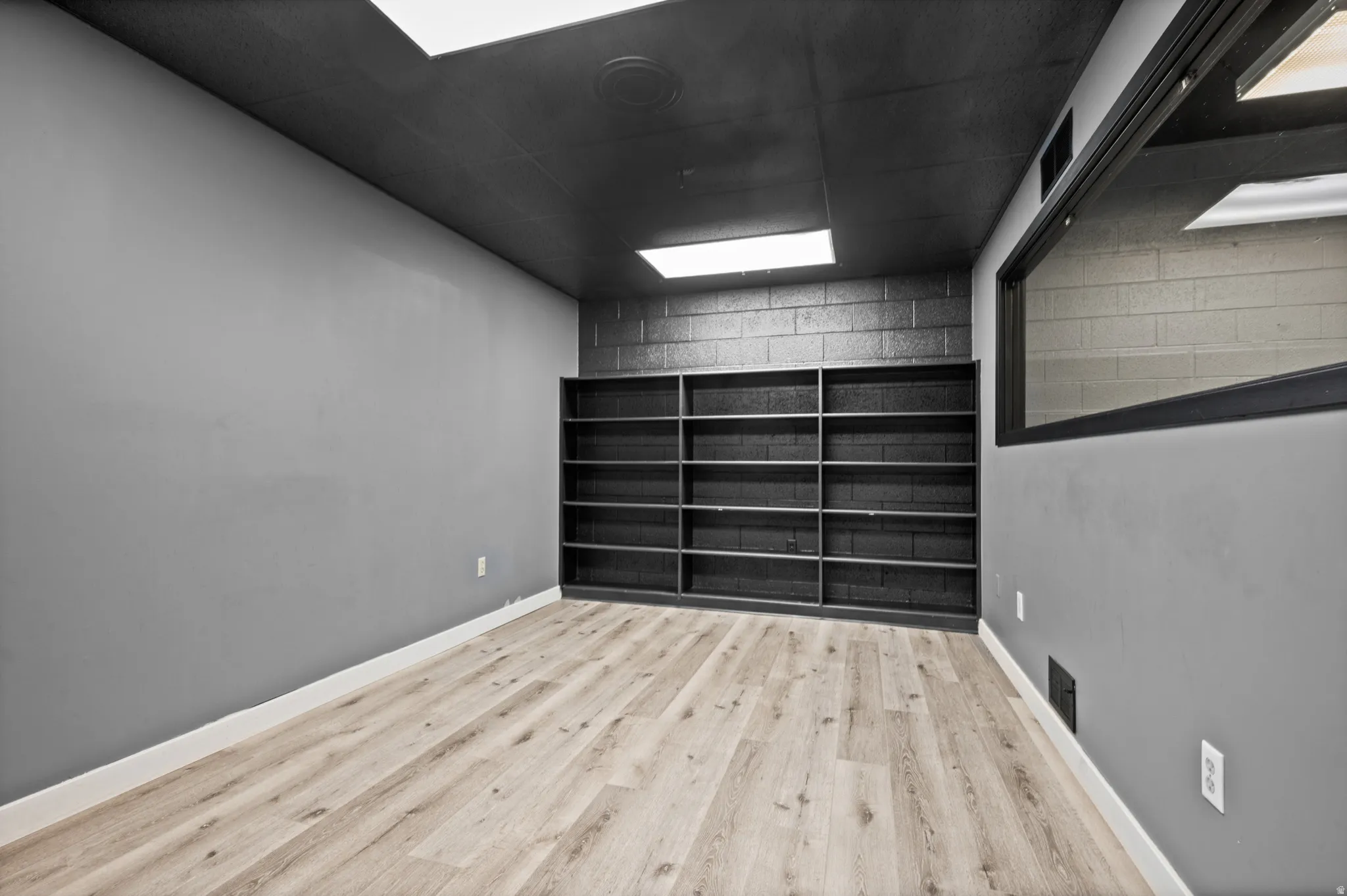 Unfurnished room featuring wood finished floors and baseboards