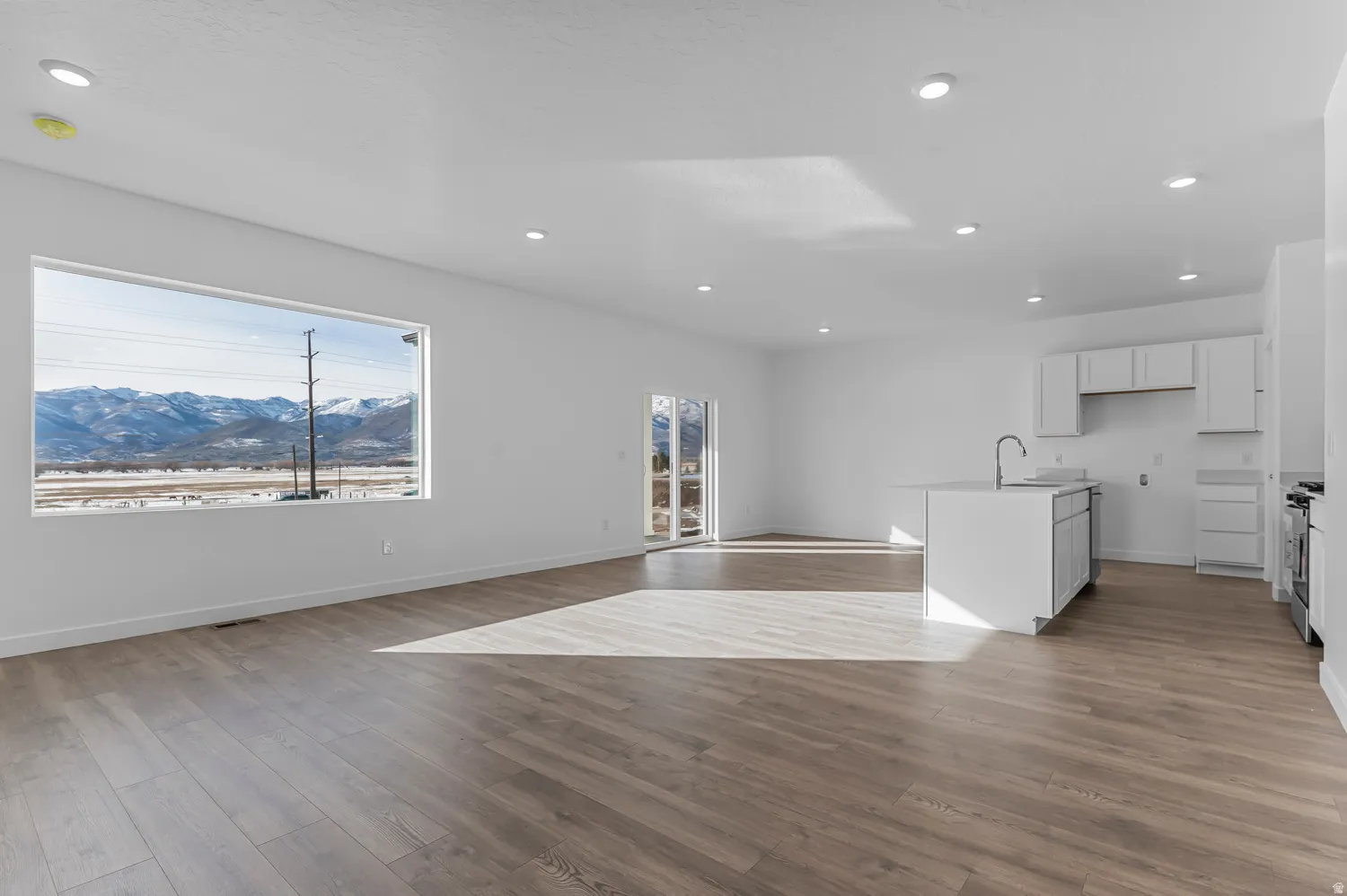 Kitchen featuring a mountain view, white cabinets, open floor plan, dark wood finished floors, and recessed lighting