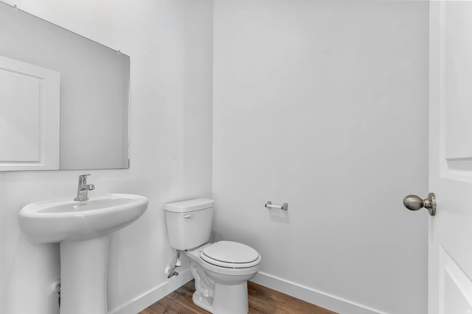 Half bath featuring dark wood-type flooring and toilet