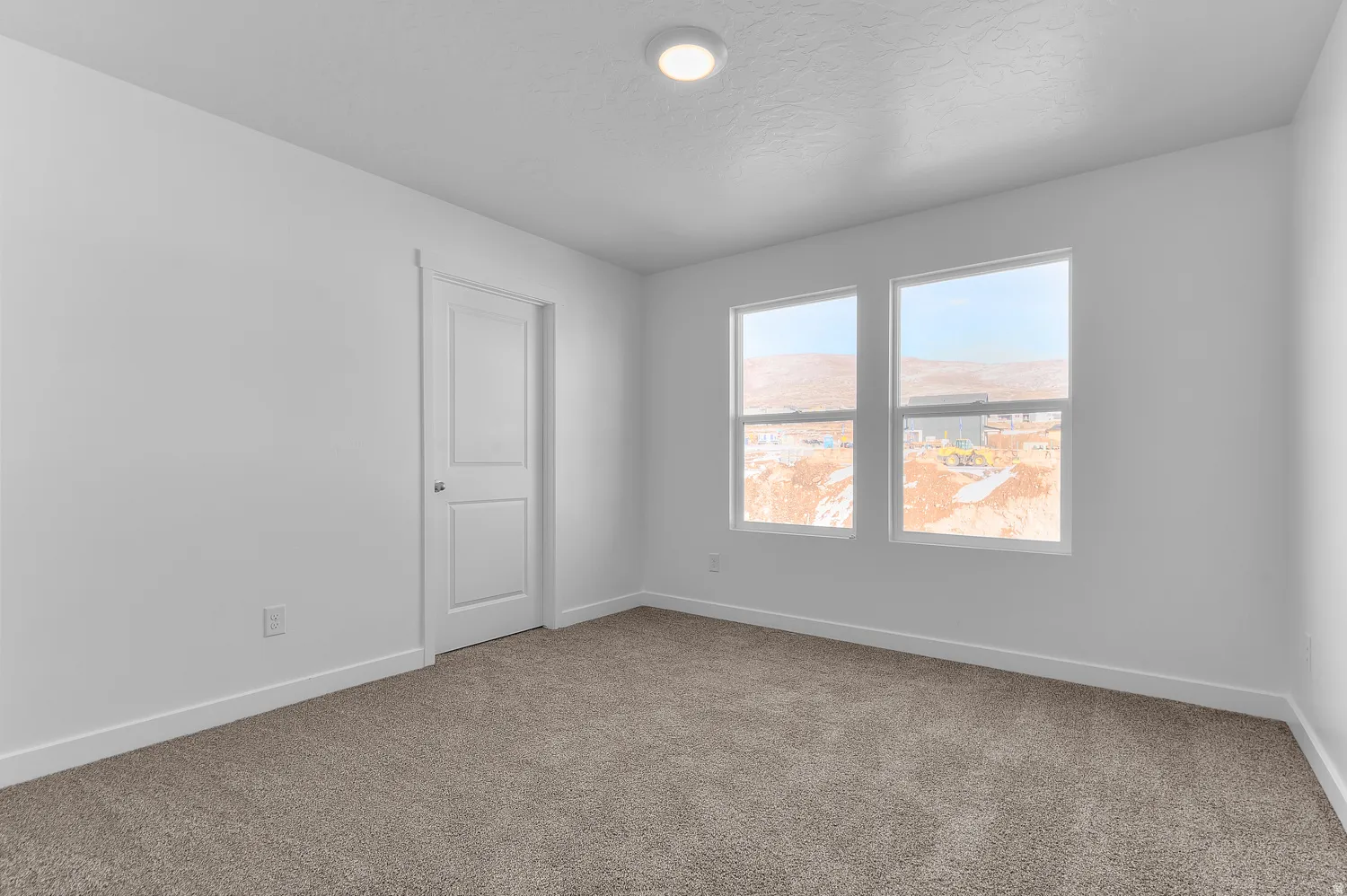 Carpeted spare room with baseboards and a textured ceiling