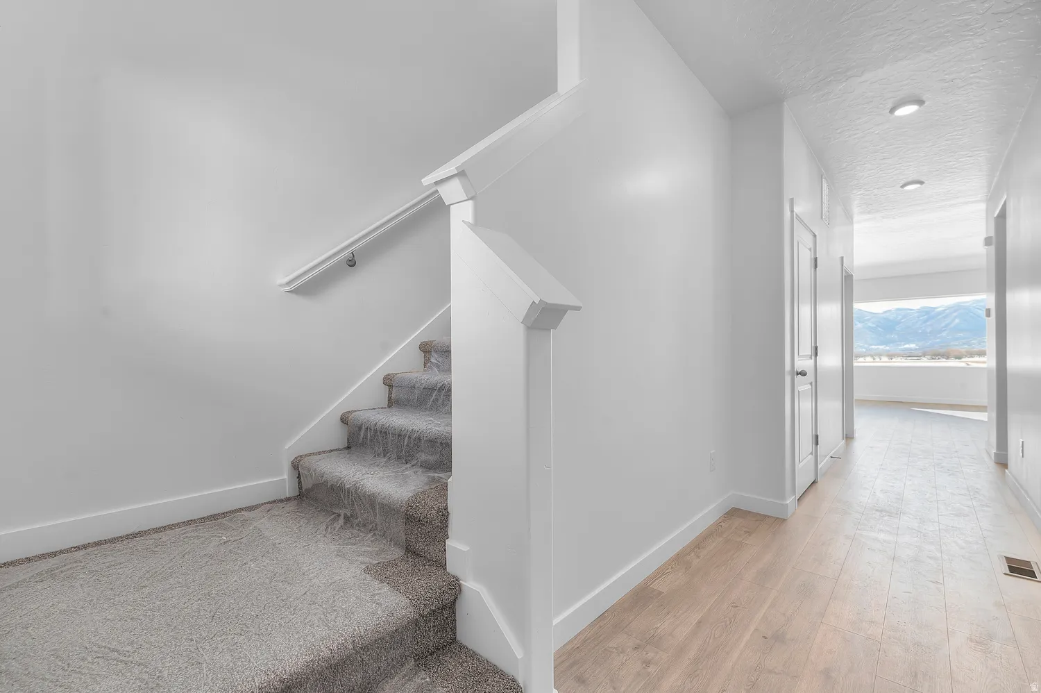 Stairway featuring a textured ceiling, hardwood / wood-style flooring, and a mountain view
