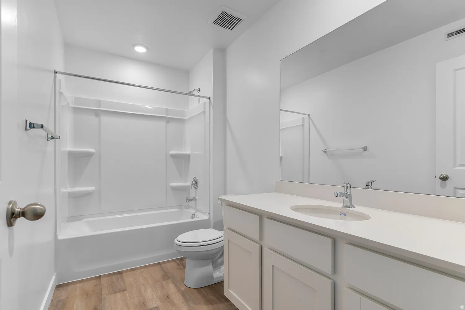 Bathroom with light wood-style floors, vanity, and shower / tub combination