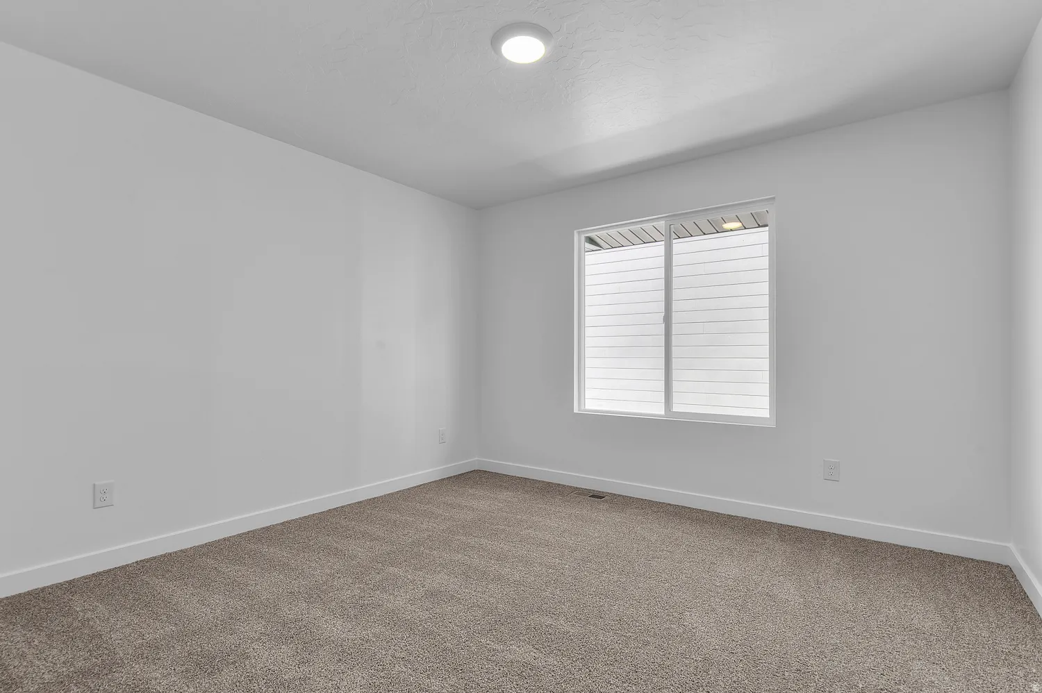 Carpeted spare room with baseboards